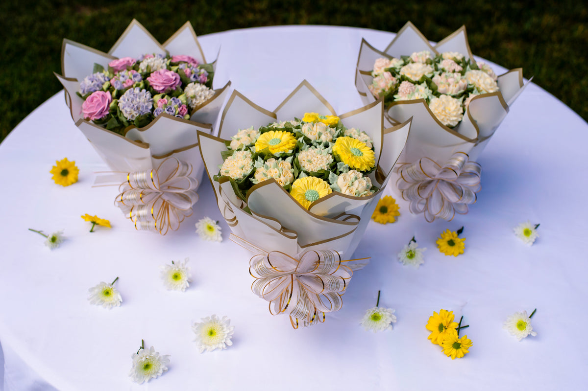 A selection of handcrafted Butter Daisy floral cupcake bouquets